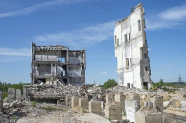Ön planda somut vakıf yığınları ile büyük bir binanın kalıntıları. Arka plan