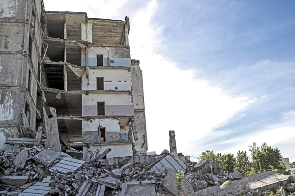 De overblijfselen van het vernietigde beton gebouw tegen de getextureerde blauwe hemel. Ruimte voor tekst. Achtergrond — Stockfoto