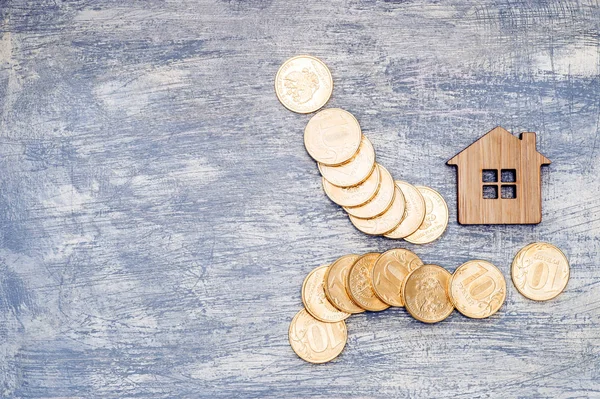 Imitation of a house with metal ten-ruble coins of Russia on a scratched background under the concrete.