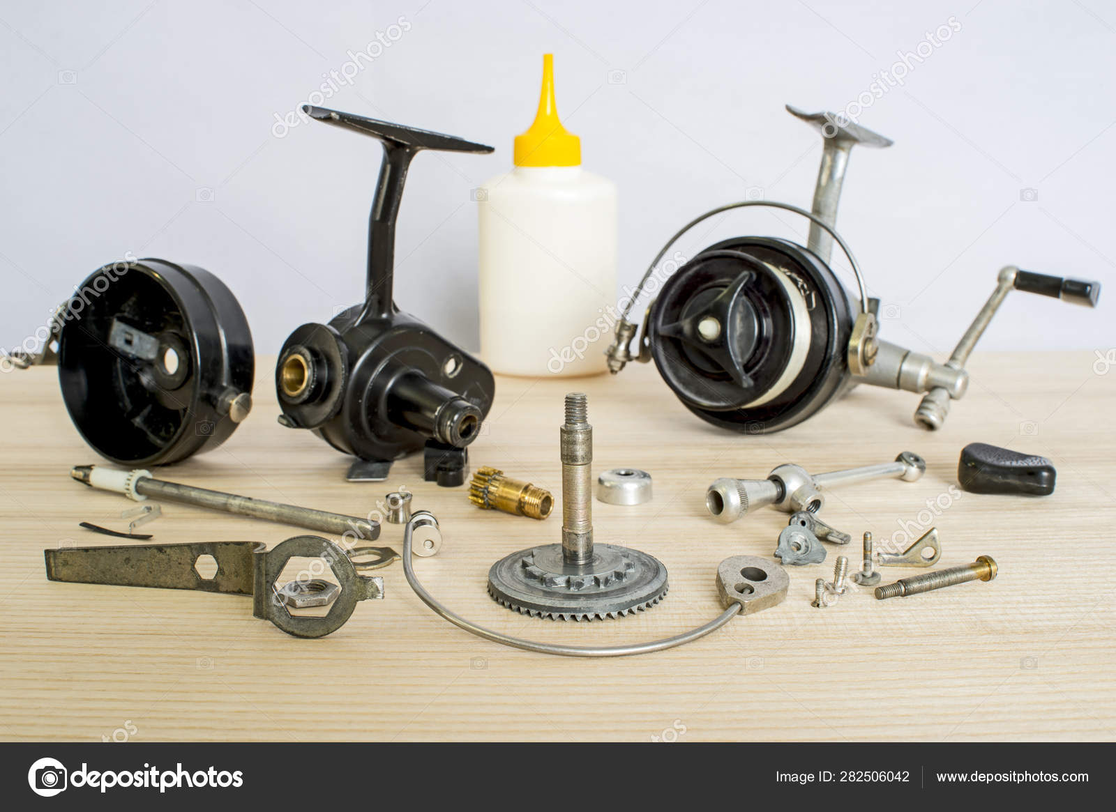 A fishing spinning reel as a whole and a second similar completely  disassembled. Concept: parts of a whole. Stock Photo by ©Ostariyanov  282506042