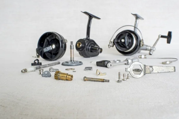 A fishing spinning reel as a whole and a second similar completely  disassembled. Concept: parts of a whole. Stock Photo by ©Ostariyanov  282506312