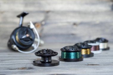 Ahşap arka planda iplik makaraları arka planda balıkçılık için balıkçılık hattı ile çok renkli makaralar ile ayarlayın.