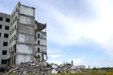 Mavi gökyüzüne karşı büyük bir binanın kalıntıları ile beton enkaz yığını. Arka plan. Metin alanı