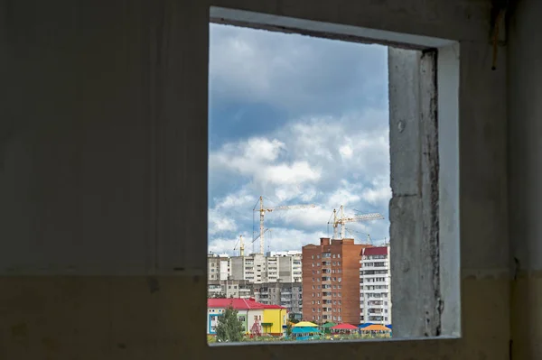 밝은 건물과 주거 분기의 새로운 건설에 오래된 집의 창에서 보기. — 스톡 사진