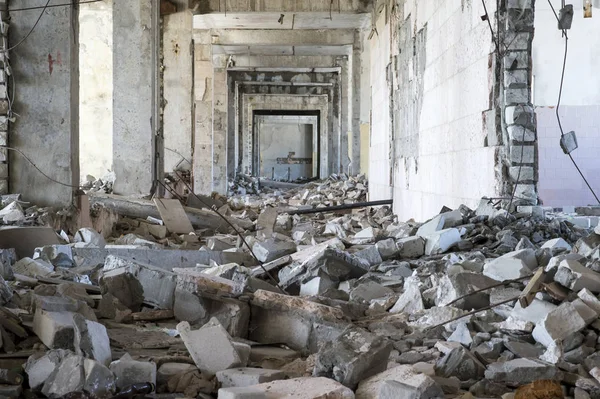 El pasillo está lleno de ladrillos y fragmentos de hormigón con el refuerzo de un gran edificio destruido. Contexto —  Fotos de Stock