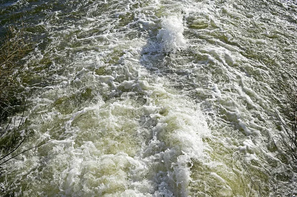 Вид сверху на кипящий ручей ниже плотины на реке в м — стоковое фото
