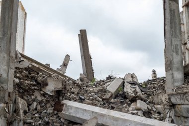 Önünde uzanan bir kiriş ve gökyüzüne doğru uzanan beton bir levha olan büyük gri beton parçalar. Yıkım konsepti. Arkaplan.
