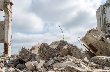 Vakfın gri beton parçaları gökyüzüne karşı yıkılan bir binanın arka planına karşı. Arkaplan.