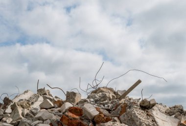 Gökyüzüne karşı gri bulutlu yıkılmış bir binanın beton parçaları. Arkaplan