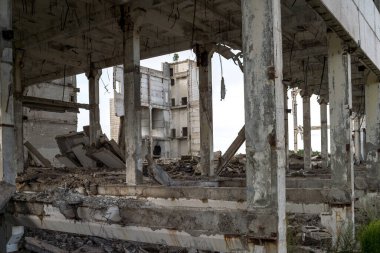 Dış duvarları olmayan büyük beton bir binayı yıkıp döşeme ve kirişlerden oluşan bir çerçeve oluşturdular. Arkaplan