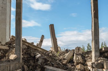 Mavi gökyüzüne karşı yıkılan bir binanın beton parçaları. Arkaplan