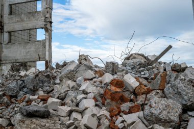 Yıkılan binanın arka planında beton döküntüler ve gri bir gökyüzü. Arkaplan.