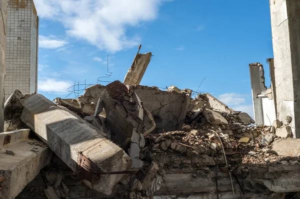 Fragmentos de betão de um edifício destruído contra o céu azul. Contexto — Fotografia de Stock