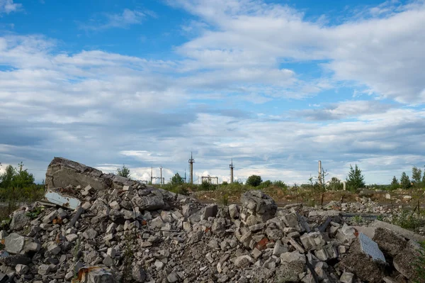 A pile of construction debris remains of a building on a vacant lot against the blue sky. Background