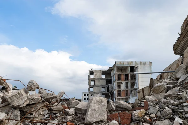 Escombros de hormigón con barras de refuerzo sobre el fondo de un edificio destruido y un cielo gris. Contexto. —  Fotos de Stock