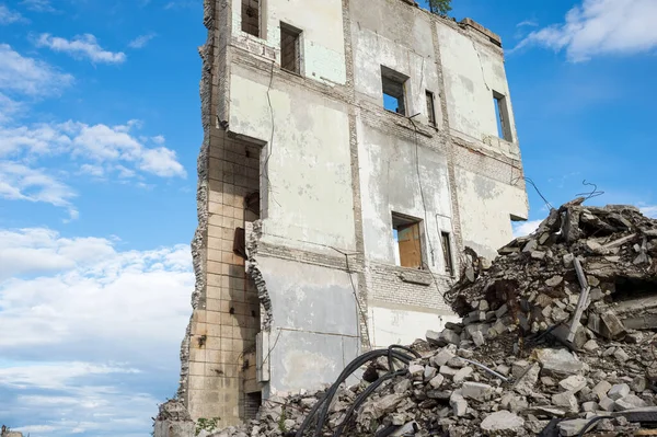 Concrete fragments of construction debris against the remains of the wall of a destroyed building. Background. — Stock Photo, Image