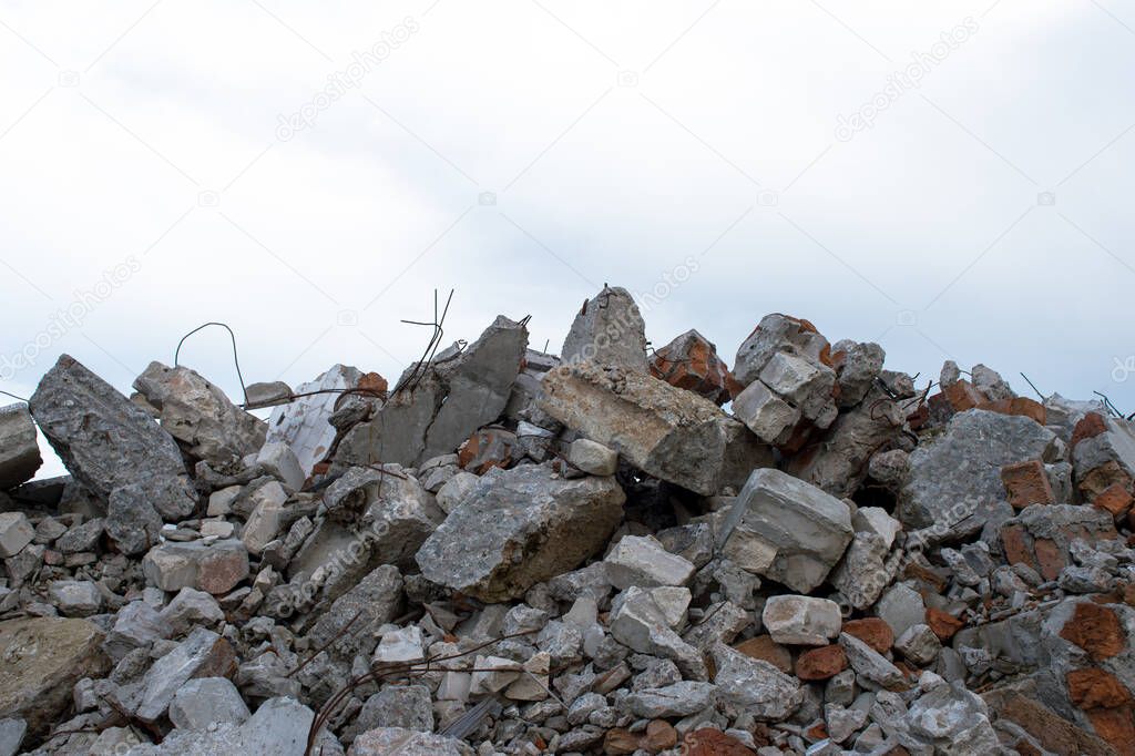 Concrete fragments of a construction structure against the gray sky. Background