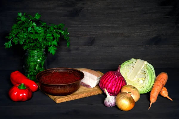 Ukrainian borscht in a vintage ceramic plate on a cutting Board with a set of vegetables for cooking. — Stock Photo, Image