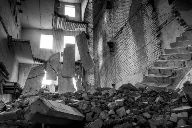 Ön planda inşaat enkazı olan yıkılmış beton bina. Arkaplan.