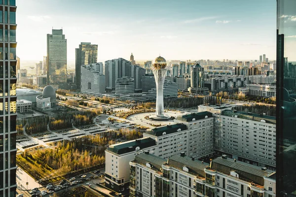 Açık bir günde Bayterek Kulesi ve bakanlıkların Astana Kazakistan'ın şoförünün doğru gün batımı görünümü
