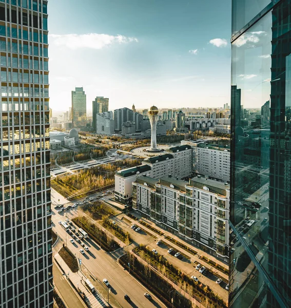 Açık bir günde Bayterek Kulesi ve bakanlıkların Astana Kazakistan'ın şoförünün doğru gün batımı görünümü