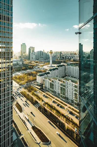 Açık bir günde Bayterek Kulesi ve bakanlıkların Astana Kazakistan'ın şoförünün doğru gün batımı görünümü