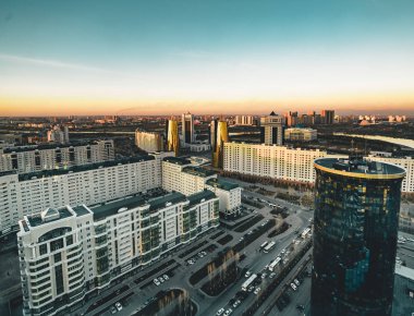 Açık bir günde Bayterek Kulesi ve bakanlıkların Astana Kazakistan'ın şoförünün doğru gün batımı görünümü