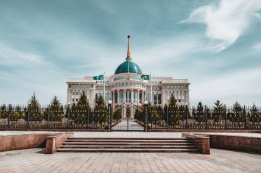 Astana, Kazakistan'ın nehrin karşısındaki mavi gökyüzü ile Cumhurbaşkanlığı Sarayı 