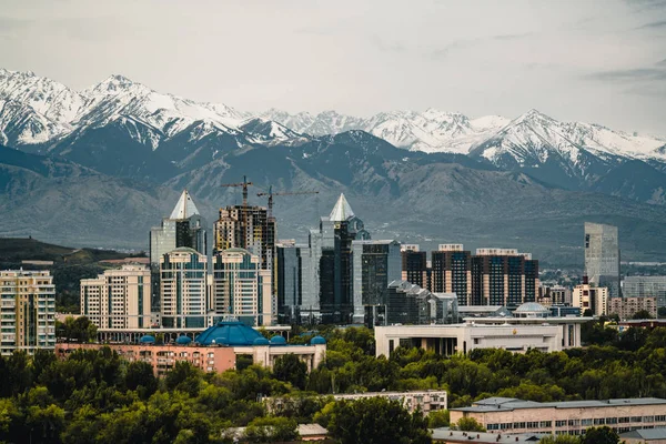 Almaty Kazakistan karla kaplı Tian Shan dağlarında bir arka plan üzerinde şehir manzarası — Stok fotoğraf