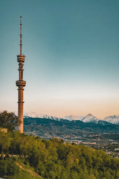 Puesta de sol sobre la ciudad de Almaty y una vista de la Torre de TV Kok Tobe — Foto de Stock