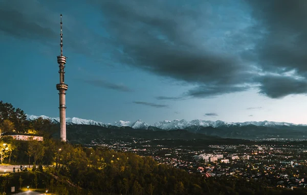 Puesta de sol sobre la ciudad de Almaty y una vista de la Torre de TV Kok Tobe — Foto de Stock