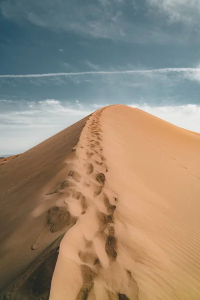 Sanddyner under blå himmel. Sahara-ørkenen. Tidligere ble husene flyttet på grunn av sandbevegelser. . – stockfoto