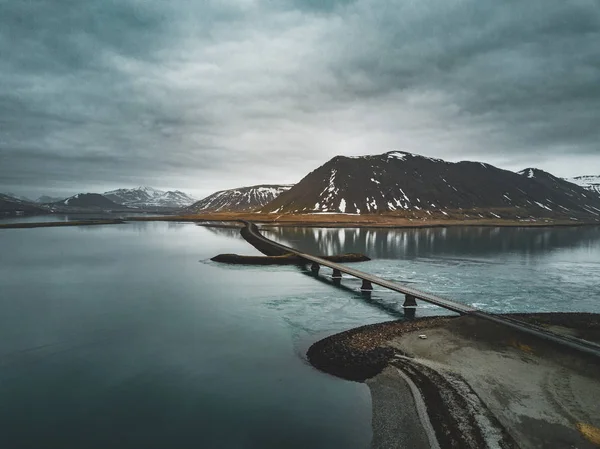 Vue aérienne de la route 1 en Islande avec pont sur la mer dans la péninsule de Snaefellsnes avec nuages, eau et montagne en arrière-plan — Photo