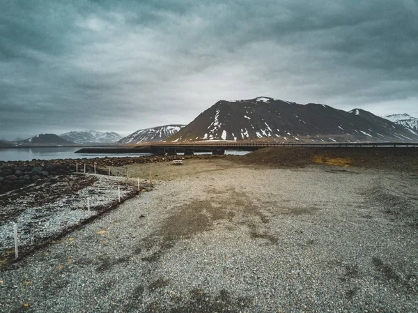 Islandia ptaka krajobraz śniegu i chmury, ulica i żółte i zielone trawy — Zdjęcie stockowe
