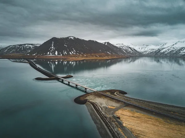 Vue aérienne de la route 1 en Islande avec pont sur la mer dans la péninsule de Snaefellsnes avec nuages, eau et montagne en arrière-plan — Photo