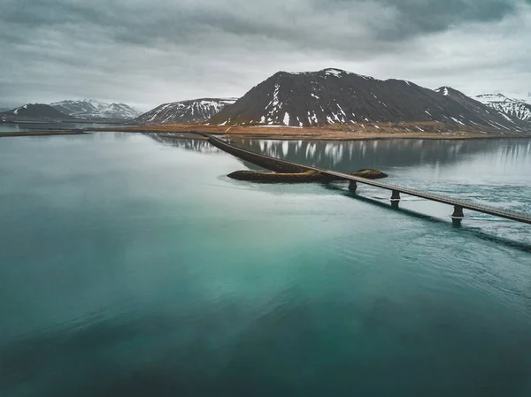 Vue aérienne de la route 1 en Islande avec pont sur la mer dans la péninsule de Snaefellsnes avec nuages, eau et montagne en arrière-plan — Photo