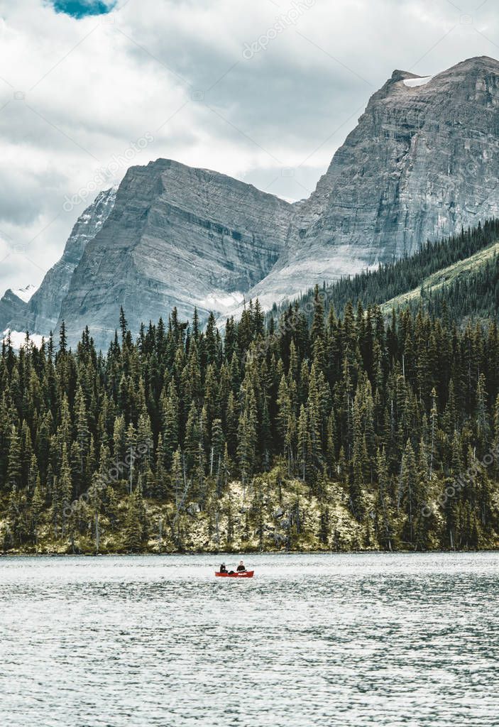 a canoe on maligne lake in summer with a backdrop of the canadian rockies in jasper national park, alberta, canada