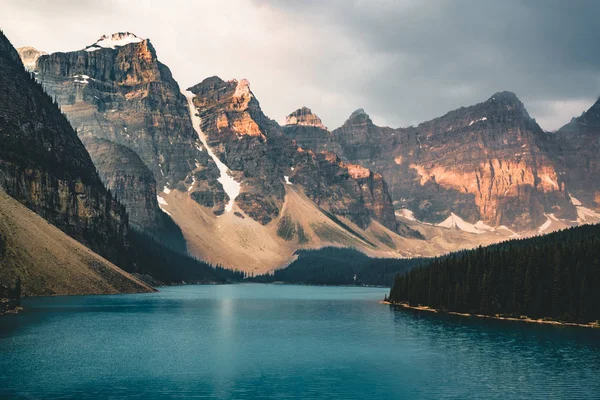 Sonnenaufgang mit türkisfarbenem Wasser des Moränensees mit sündhaft beleuchteten felsigen Bergen im Banff-Nationalpark von Kanada im Tal der zehn Gipfel. — Stockfoto