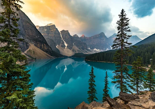 Sonnenaufgang mit türkisfarbenem Wasser des Moränensees mit sündhaft beleuchteten felsigen Bergen im Banff-Nationalpark von Kanada im Tal der zehn Gipfel. — Stockfoto