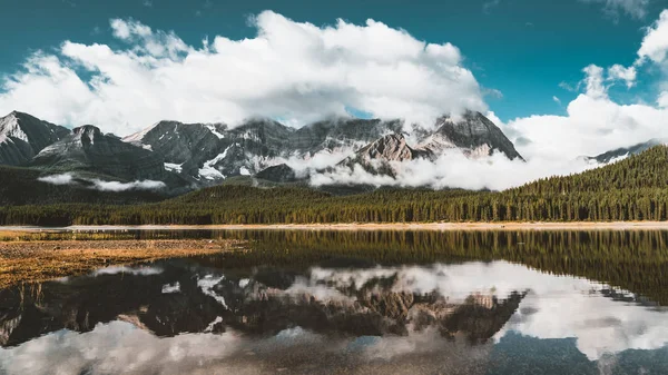 Reflexão com lago e montanhas baixo suspensas couds em Lower Kananaskis Lago de Peter Lougheed Provincial Park Kananaskis País Alberta Canadá — Fotografia de Stock