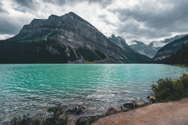 Hermosa naturaleza del lago Louise en primer plano y montaña en el fondo en el Parque Nacional Banff, Canadá Alberta . — Foto de Stock