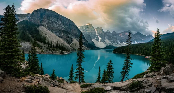 Panorama View Sunrise with turquoise waters of the Moraine lake with sin lit rocky mountains in Banff National Park of Canada in Valley of the ten peaks.