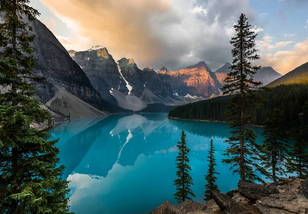 Sunrise with turquoise waters of the Moraine lake with sin lit rocky mountains in Banff National Park of Canada in Valley of the ten peaks. — Stock Photo, Image