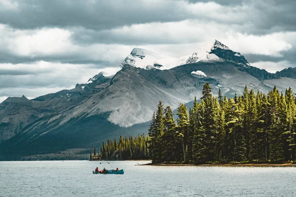 Un canot sur le lac maligne en été avec en toile de fond les rochers canadiens dans le parc national du jaspe, alberta, canada — Photo