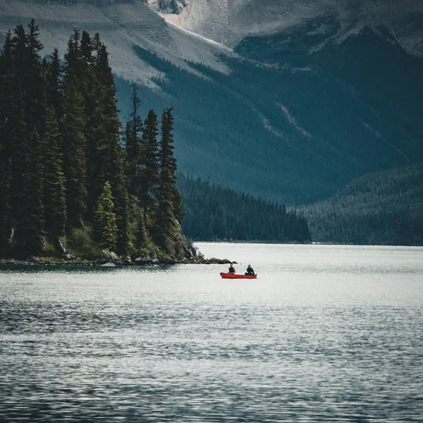 Un canot sur le lac maligne en été avec en toile de fond les rochers canadiens dans le parc national du jaspe, alberta, canada — Photo