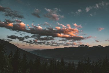 Mount Revelstoke mavi gökyüzü ve bulutlar ile orman genelinde günbatımı manzara. British Columbia Kanada.