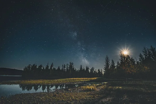 Vía Láctea galaxia cielo nocturno sobre bosque con luna y reflexión. Isla de Vancouver, Tofino, Canadá —  Fotos de Stock