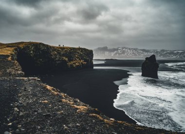 Ünlü siyah kum Beach Reynisfjara İzlanda'daki güneş doğarken. Rüzgarlı sabah. Okyanus dalgaları. Renkli gökyüzü. Sabah günbatımı.