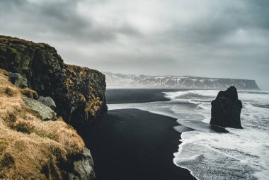 Ünlü siyah kum Beach Reynisfjara İzlanda'daki güneş doğarken. Rüzgarlı sabah. Okyanus dalgaları. Renkli gökyüzü. Sabah günbatımı.