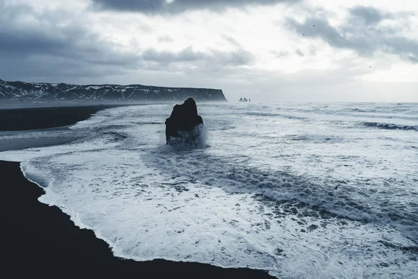 Ünlü siyah kum Beach Reynisfjara İzlanda'daki güneş doğarken. Rüzgarlı sabah. Okyanus dalgaları. Renkli gökyüzü. Sabah günbatımı.